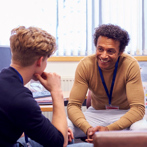 A counselor speaks with a young man in his office