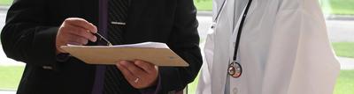 One doctor, one administrator examining clipboard