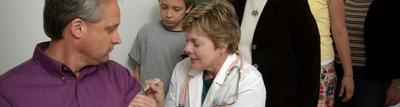 A doctor gives a shot to an adult patient